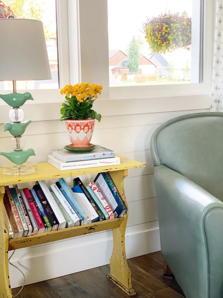 Bird-shaped lamp placed above a bookshelf