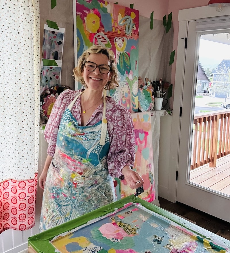 Mixed Media Artist Kelly Rae Roberts posing with her large canvas artwork