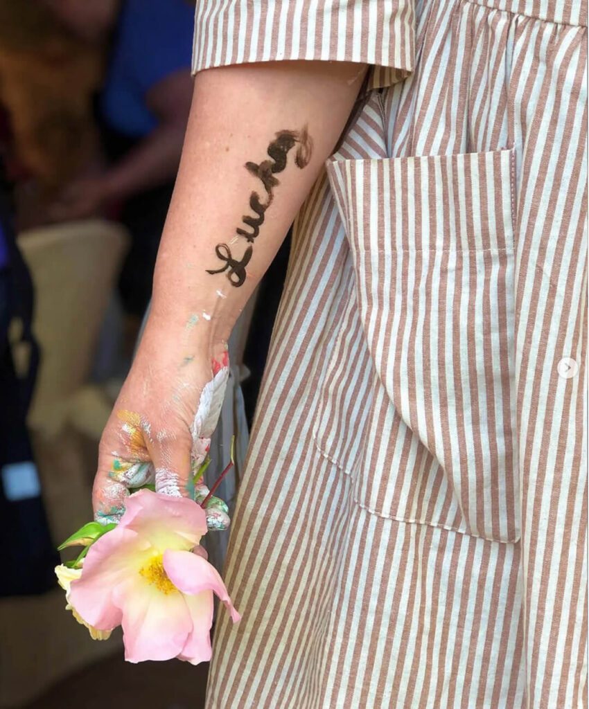 Kelly Rae Roberts Lucky marker arm tatoo with flower in hand
